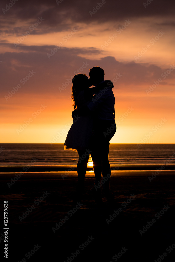 Love couple silhouette during sunset at the beach