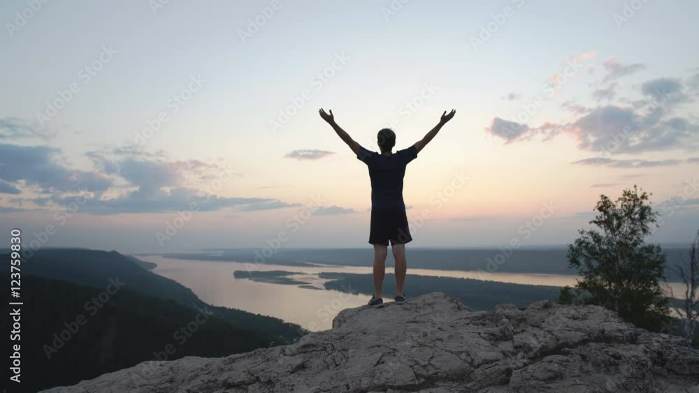 silhouette of a businessman with a laptop in hand is on top of a mountain in the sky with clouds. silhouette of a businessman with a laptop in hand is on top of a mountain in the sky with clouds.