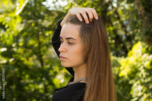 Young woman standing back on the background of trees