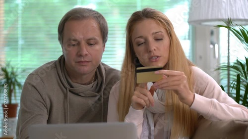 Couple doing online purchases uses gold credit card. photo