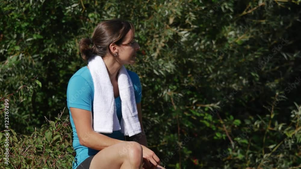 Beautiful young sport woman with towel resting after workout sport exercises outdoors Beautiful young sport woman with towel resting after workout sport exercises outdoors