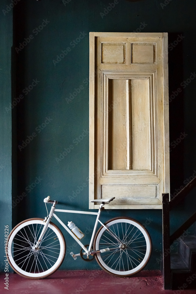 A white fixed gear bike with window background