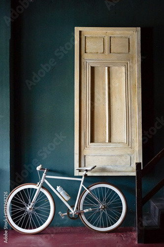 A white fixed gear bike with window background