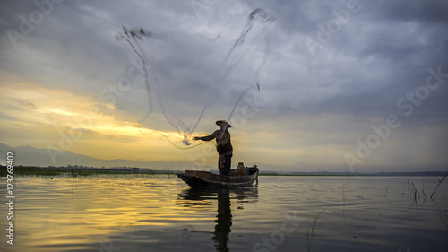 Fisherman of Bangpra Lake in action when fishing in the sunshine morning, Thailand