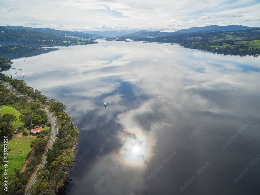 Aerial panorama of Huon River with clouds reflecting in the water. Huon Valley, Tasmania, Australia