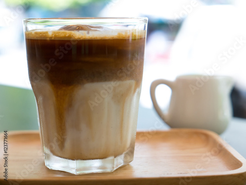 Iced coffee in wooden plate on table