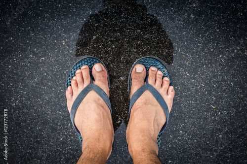 Top view feet in sandals selfie shot of asian men legs with wet street