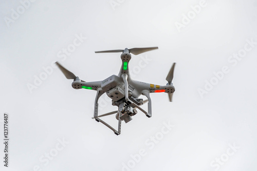 Fototapeta Naklejka Na Ścianę i Meble -  A drone with a camera flying high above a residential area
