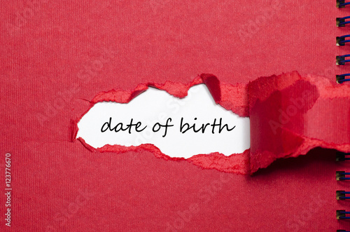 The word date of birth appearing behind torn paper