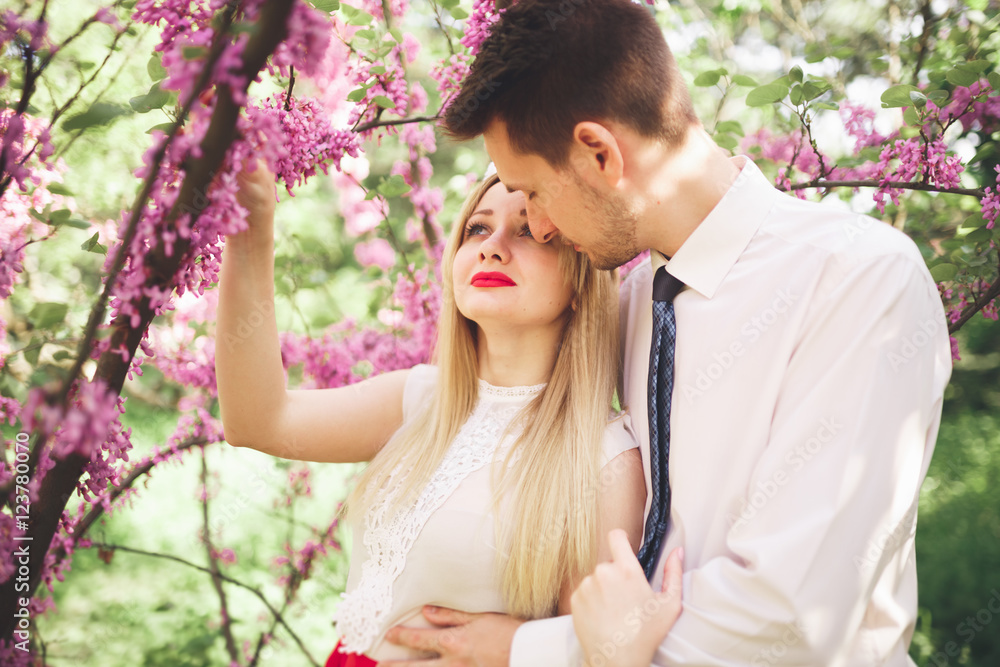 Stylish beautiful happy wedding couple kissing and embracing in Botanical Garden Stylish beautiful happy wedding couple kissing and embracing in Botanical Garden