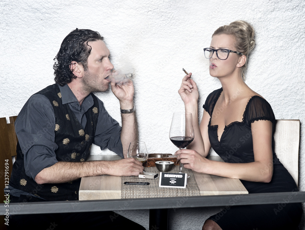 Couple smoking cigars drinking alcohol in the restaurant