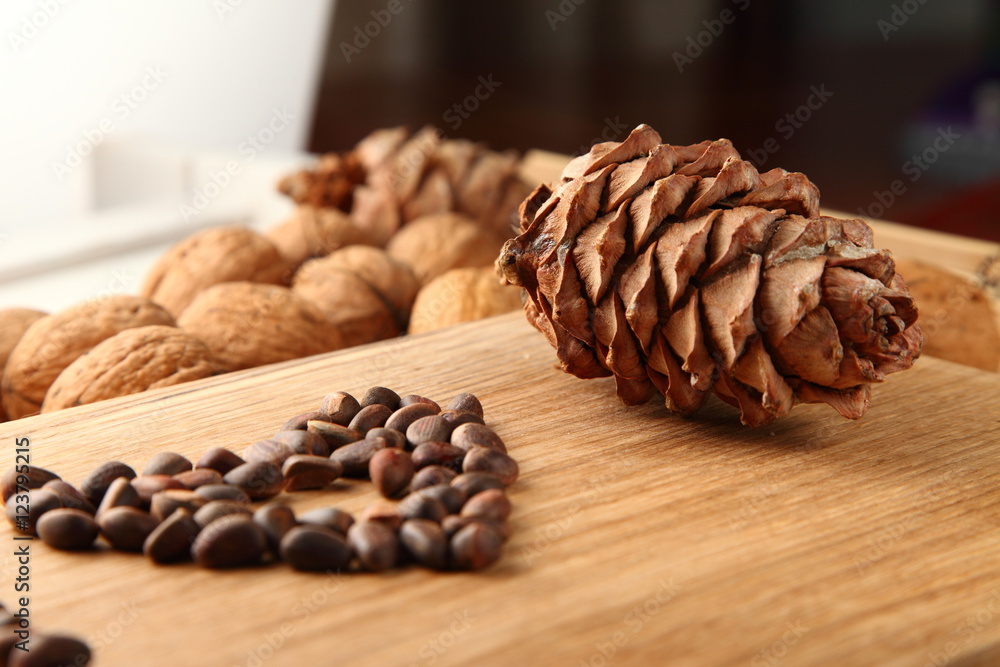 Walnut and pine nuts on a cutting board made of oak/ Walnut and pine nuts on a cutting board made of oak Walnut and pine nuts on a cutting board made of oak/ Walnut and pine nuts on a cutting board made of oak