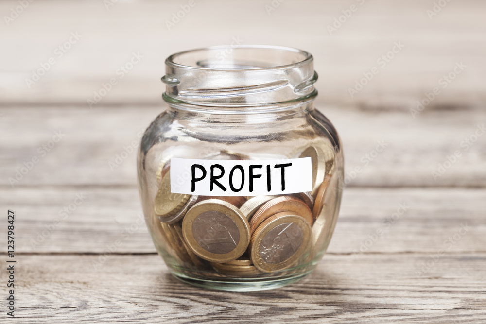 Money in the glass on wood table. Money Saving concept