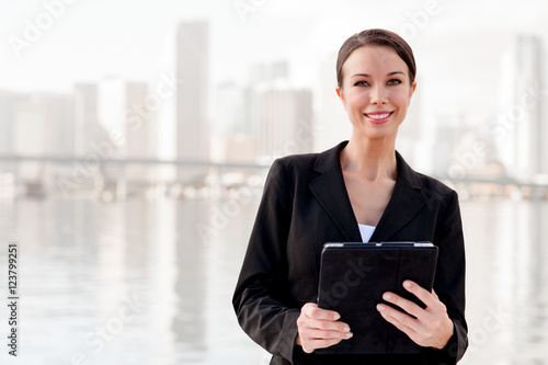 Businesswoman with digital tablet and miami skyline in backgroun