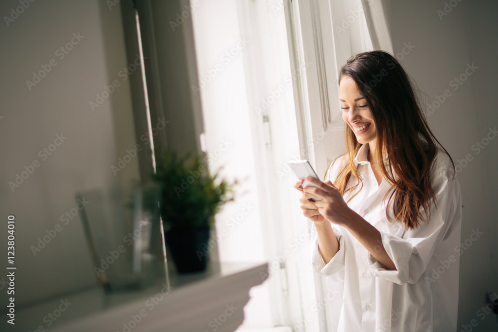 Beautiful woman using phone in house Beautiful woman using phone in house