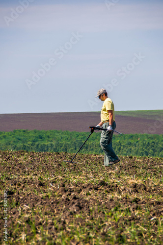 Man with metal detector in a field