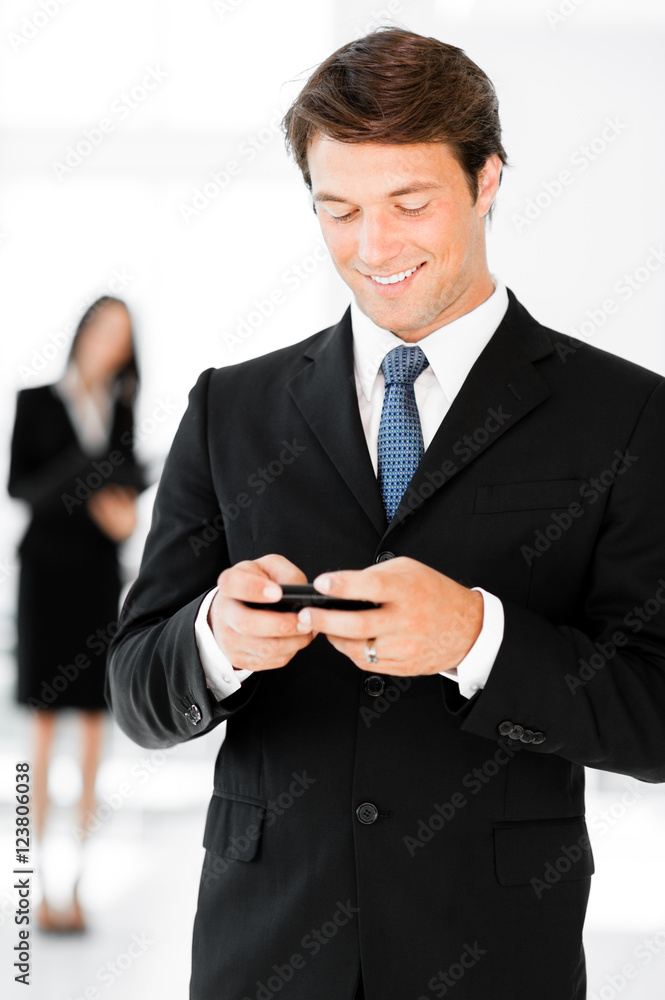 Businessman texting on mobile phone in hotel office lobby