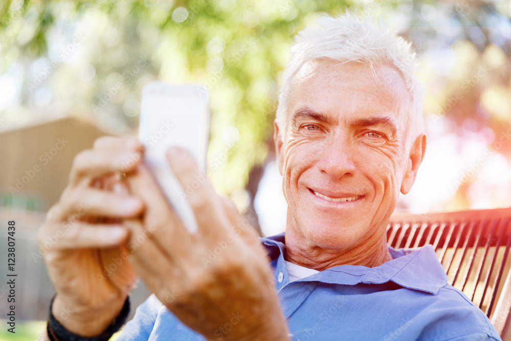 LoMature man outdoors using mobile phone LoMature man outdoors using mobile phone