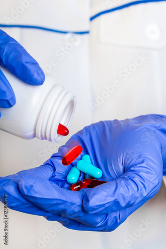 Doctor pouring pills on hand.