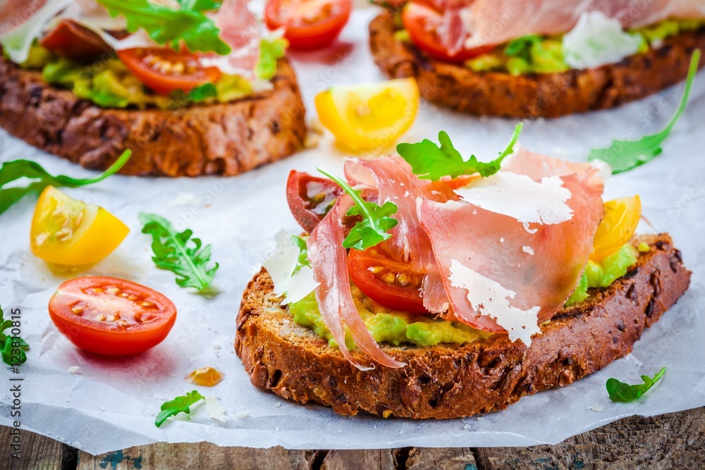 bruschetta with prosciutto, avocado, tomatoes, arugula and cheese bruschetta with prosciutto, avocado, tomatoes, arugula and cheese