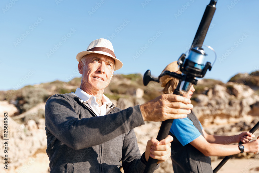Fototapeta premium Senior man fishing with his grandson