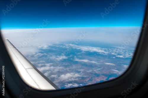 The plane fly on the background of picturesque cloud. View from the porthole. Wide angle