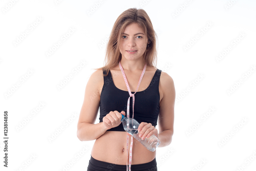 smiling slender girl standing right and holding water bottle smiling slender girl standing right and holding water bottle