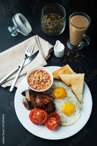 English cooked breakfast with bacon, sausage, fried egg