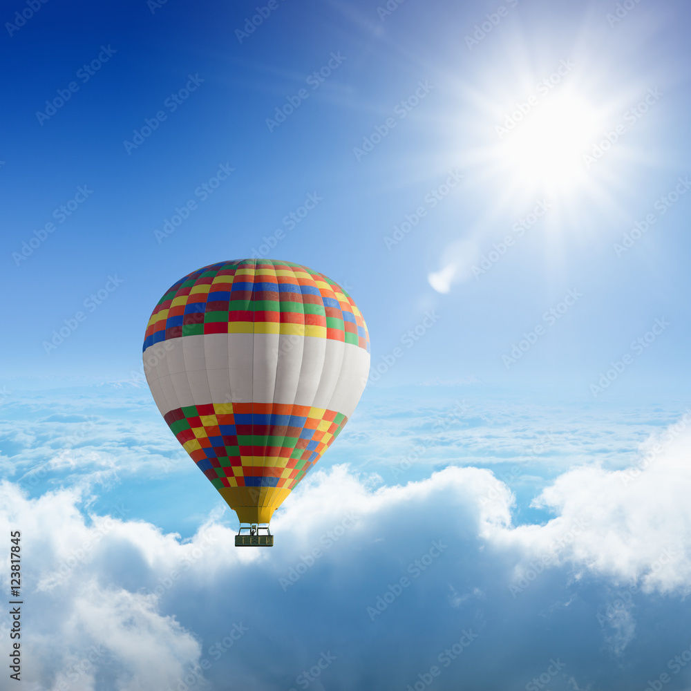 Naklejka premium Hot air balloon flies very high in blue sky