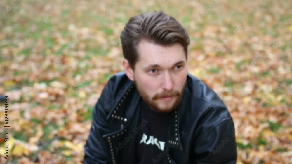 The bearded man sits on his haunches. The bearded man sits on his haunches.