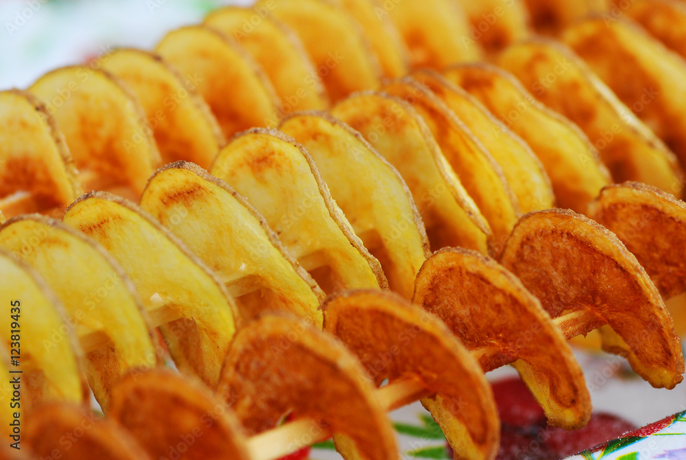 Bunch of fried spiral potato skewers. Fried spiral slice potato skewers Bunch of fried spiral potato skewers. Fried spiral slice potato skewers