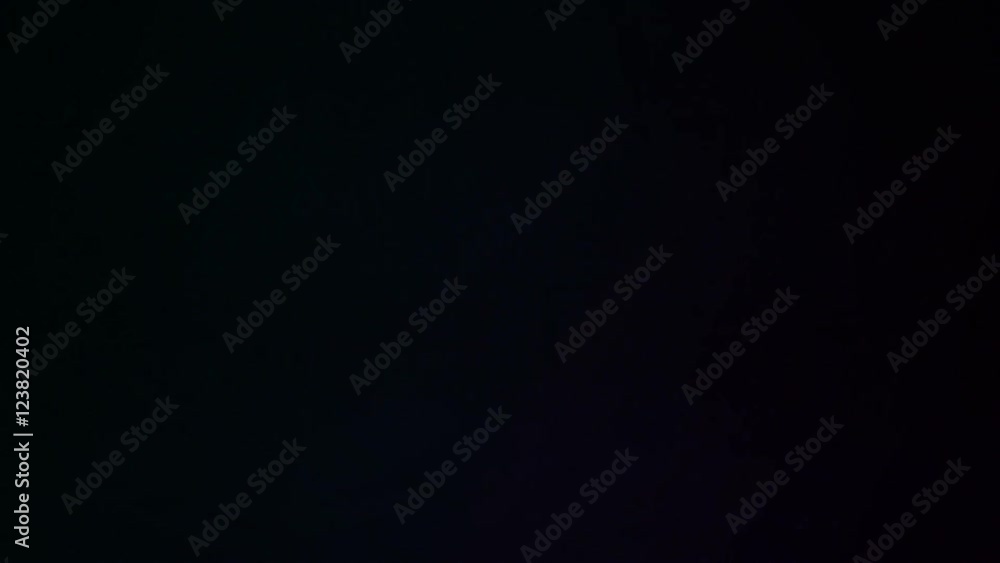 Young man drinking whiskey with ice over black background Young man drinking whiskey with ice over black background