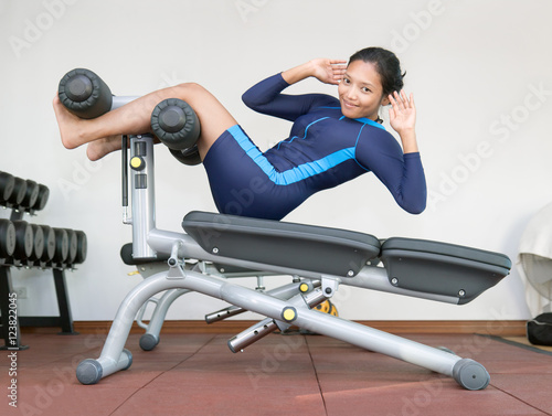 woman practicing sit-ups on exercise machines at the gym
