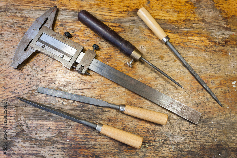 Caliper, files and pricker on a table in a workshop Caliper, files and pricker on a table in a workshop