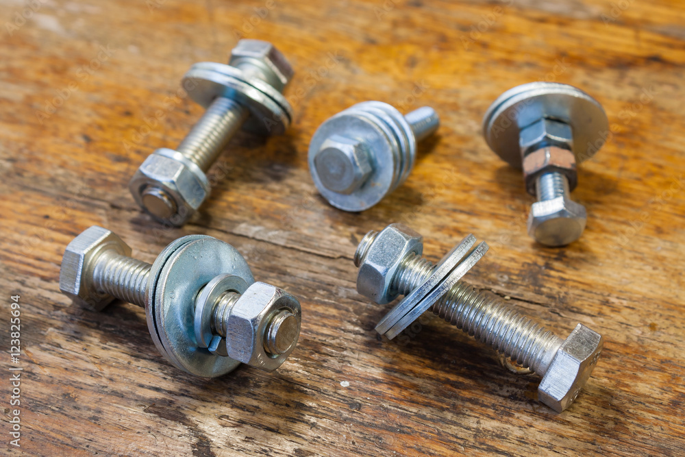 Assembly set bolts and nuts on a table in a workshop Assembly set bolts and nuts on a table in a workshop