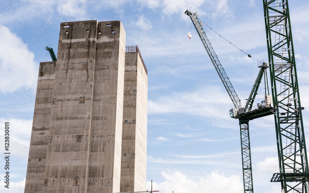 Fototapeta premium Construction site with two big cranes and concrete core of new skyscraper