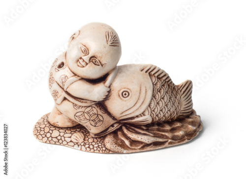 Netsuke of the boy with big fish. Isolated. A miniature sculptur