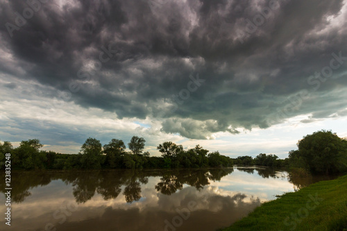 Ominous stormy sky over natural flooded river