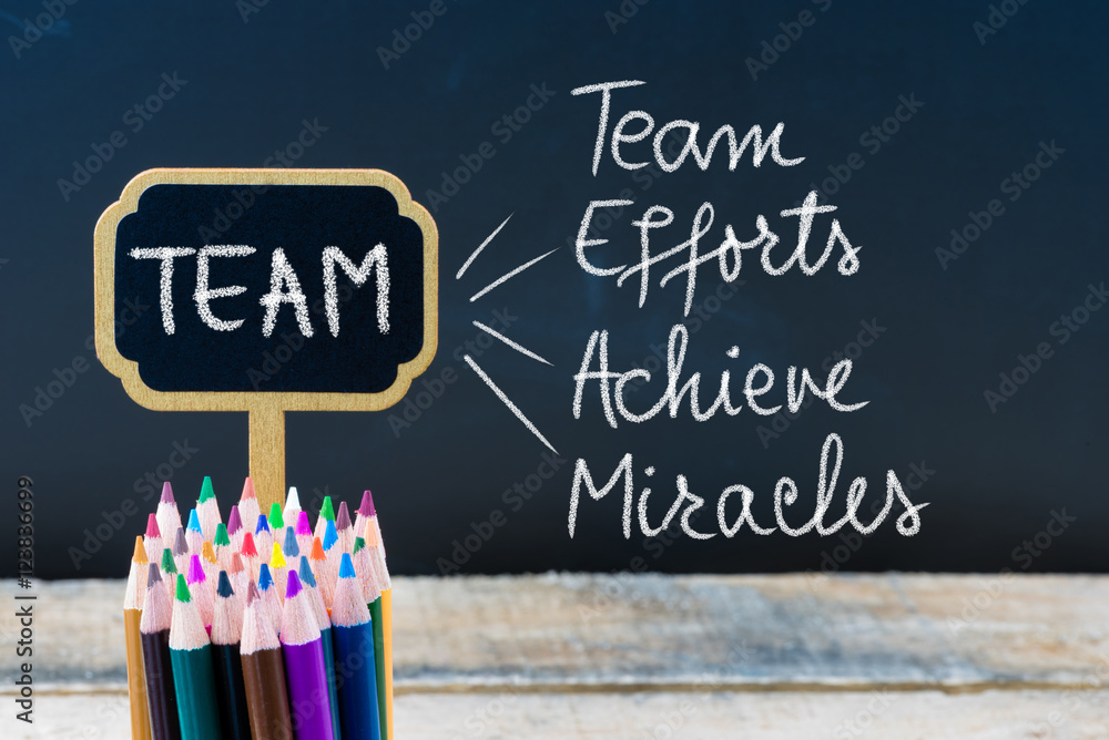 Business Acronym TEAM as Team Efforts Achieve Miracles written with chalk on wooden mini blackboard labels