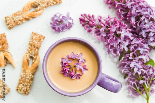 Spring lilac flowers with mug of coffee