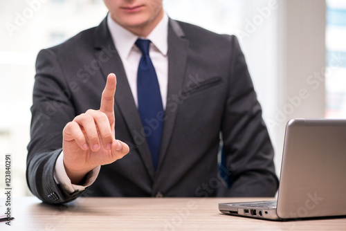 Young businessman pressing buttons in business concept