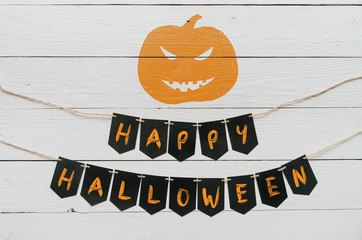 Handwritten happy halloween banner lettering, cut pumpkin on white rustic painted barn wood background