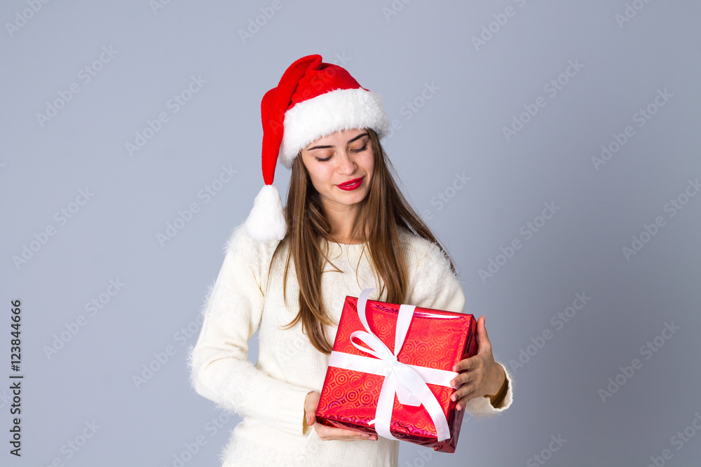 Woman in red christmas hat holding presents Woman in red christmas hat holding presents