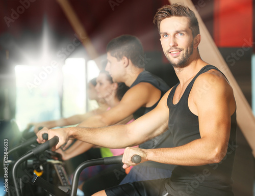 People training on exercise bike in gym