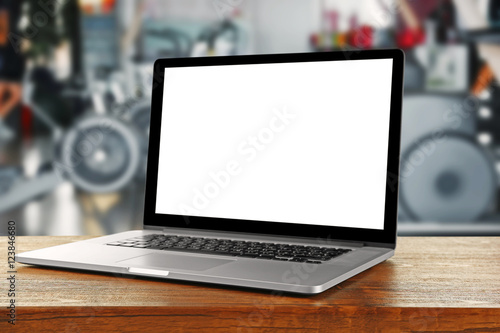 Laptop with blank screen on blurred gym background photo