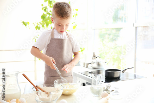 Little boy in kitchen makin...