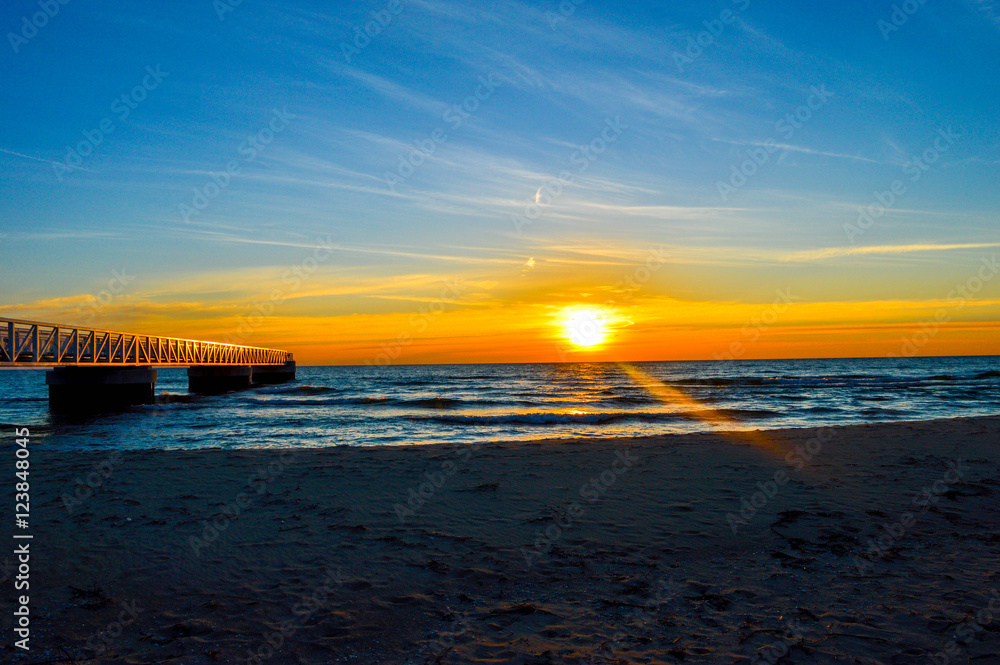 Fototapeta premium Brilliant sunrise over the waters of Lake Huron in Oscoda, Michigan
