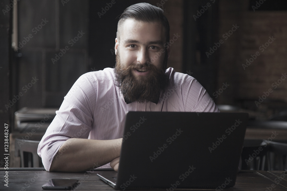 Portrait of a young bearded businessman working with laptop (Suc Portrait of a young bearded businessman working with laptop (Suc