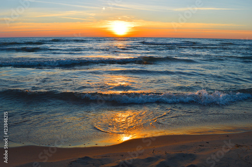 Brilliant sunrise over the waters of lake Huron in Oscoda, Michigan photo