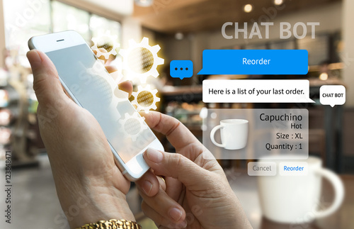 Chat bot and future marketing concept . Customer hand holding smart phone for reorder coffee and popup out phone screen with automatic chatbot message screen , coffee shop background photo